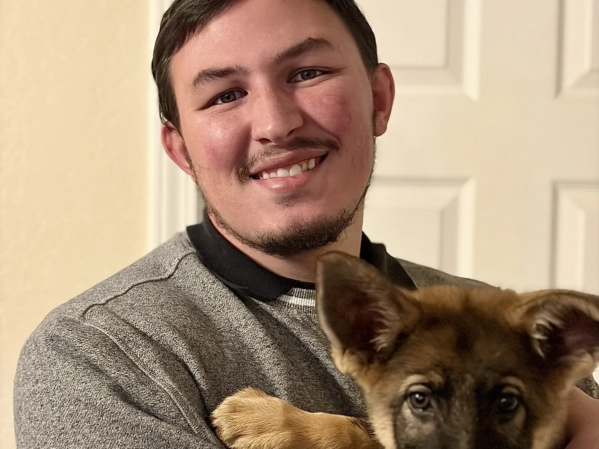 Owner Austin Todd holding a German Shepherd puppy