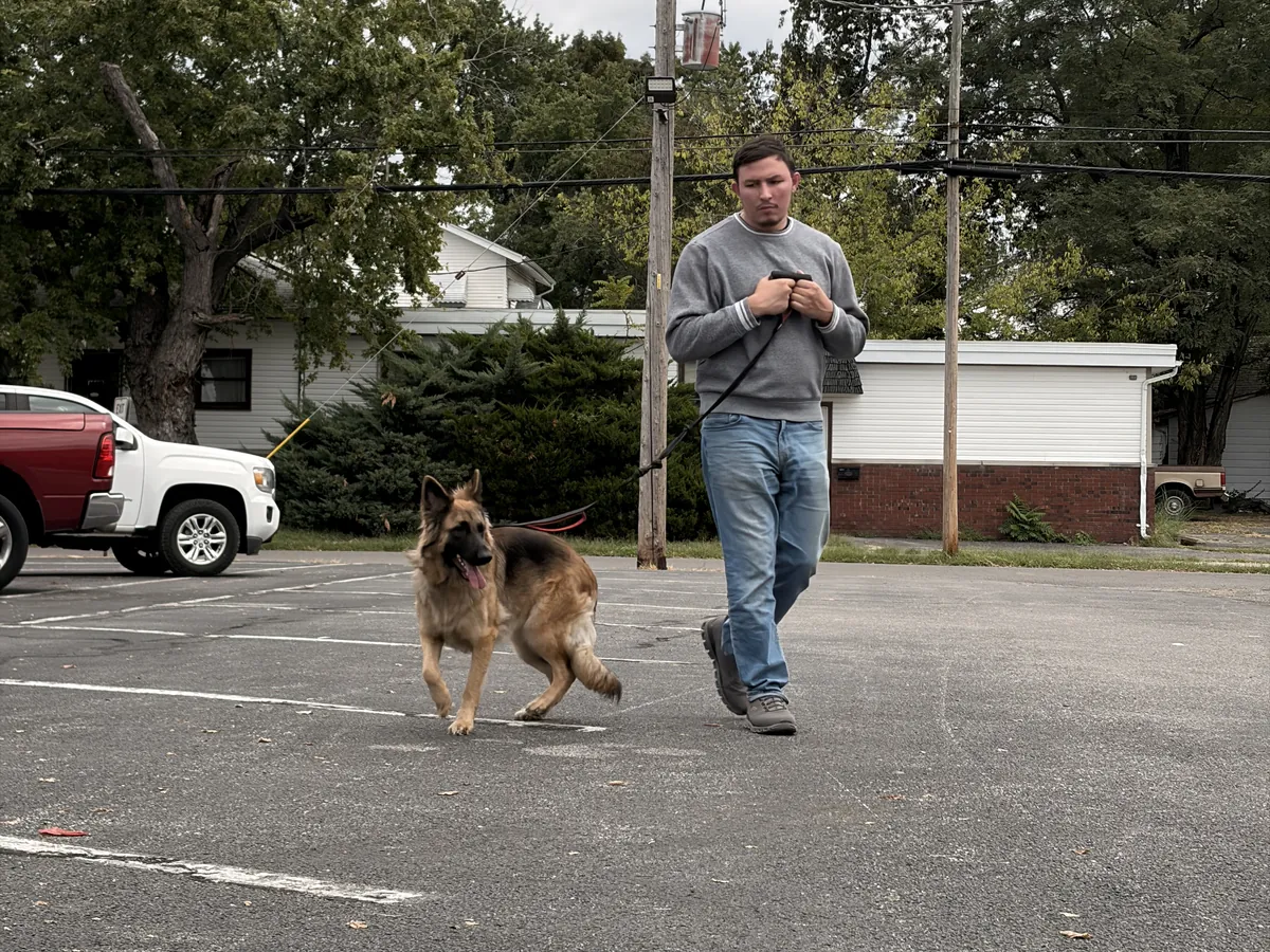 Owner Austin Todd walking a German Shepherd on a loose leash outside the Rising Sun facility in Marion