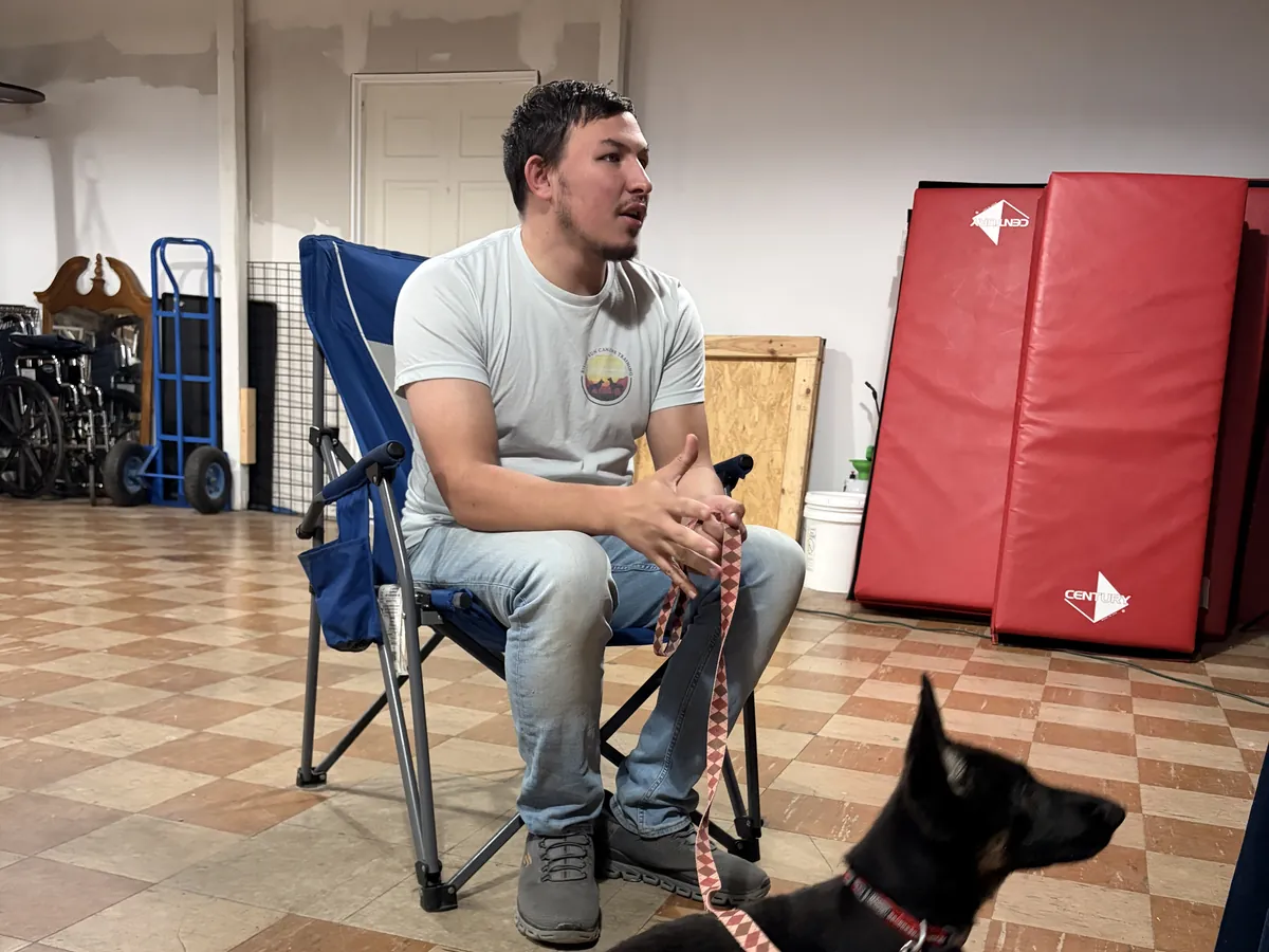 Owner Austin Todd sitting calmly while a German Shepherd puppy settles on a leash at the Rising Sun facility